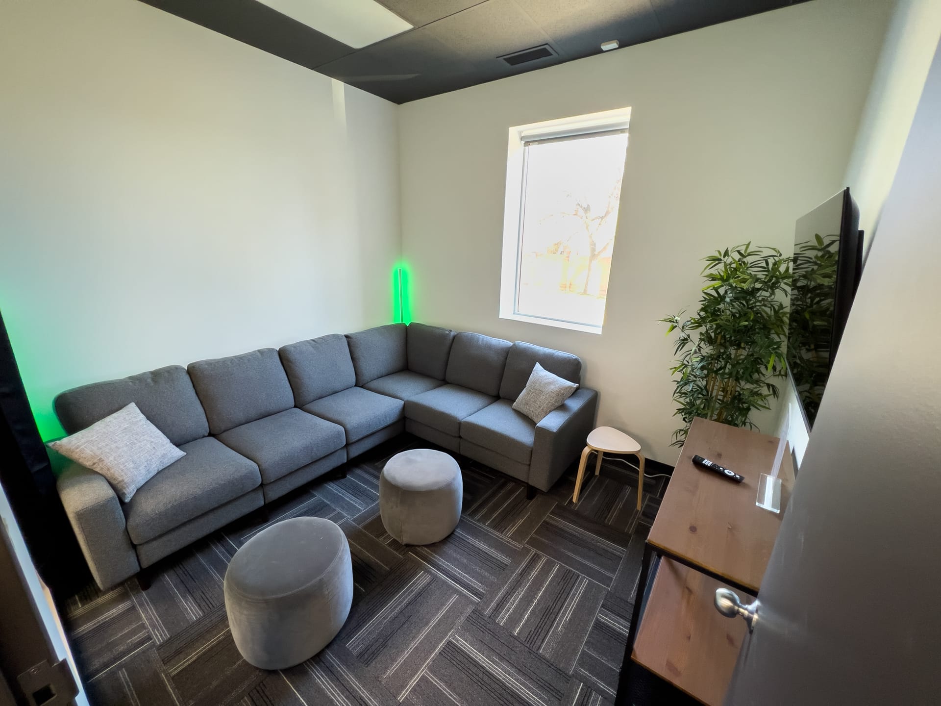 Green room lounge with a sectional sofa and playback TV at Viva Studios